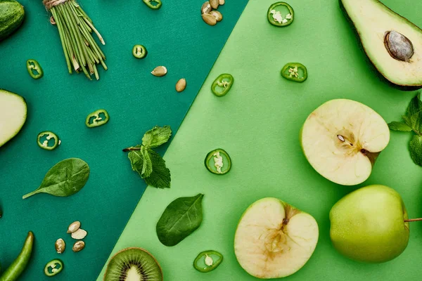 Vista superior de abacate fresco, pimentas, kiwi, vegetação, sementes de abóbora e maçãs — Fotografia de Stock