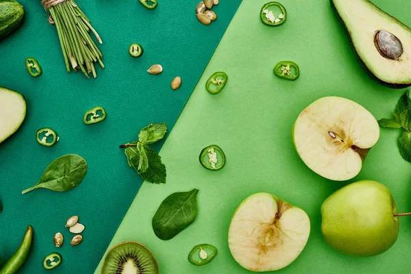 Top view of fresh avocado, peppers, kiwi, greenery, pumpkin seeds and apples — Stock Photo