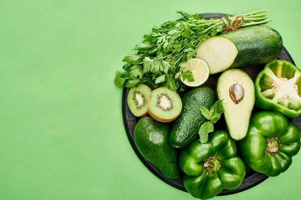 Blick von oben auf Avocados, Paprika, Kiwi, Limetten, Zucchini und Grün auf Pizza-Pfanne — Stockfoto