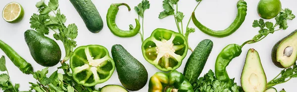 Panoramic shot of limes, peppers, greenery, cucumbers and avocados — Stock Photo