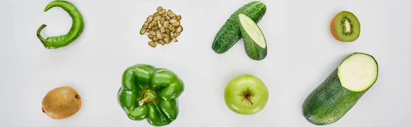 Tiro panorâmico de kiwi, pimentas, sementes de abóbora, pepinos, abobrinha e maçãs — Fotografia de Stock