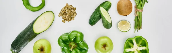 Panoramic shot of peppers, cucumbers, apples, zucchini, kiwi, pumpkin seeds, lime, greenery and avocados — Stock Photo