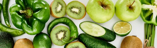 Panoramic shot of peppers, cucumbers, kiwi, lime, apples and avocado — Stock Photo