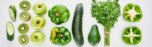 Panoramic shot of peppers, cucumbers, zucchini, kiwi, apples, greenery and avocado — Stock Photo