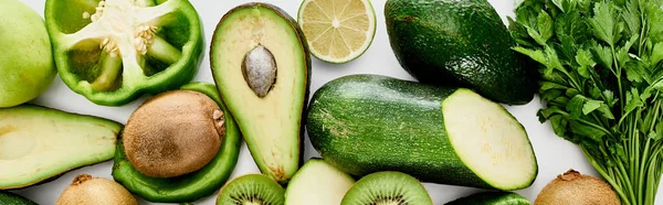 Panoramic shot of peppers, zucchini, kiwi, lime, greenery and avocados — Stock Photo