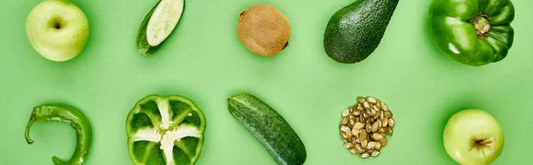Tiro panorâmico de pimentas, pepinos, quivi, maçãs, sementes de abóbora e abacate — Fotografia de Stock