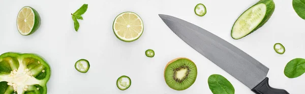 Vue du haut du couteau, concombres frais, kiwi, chaux, poivrons et verdure — Photo de stock