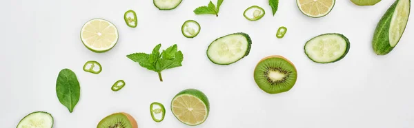 Coup panoramique de concombres frais, kiwi, citrons verts, poivrons et verdure — Photo de stock