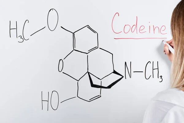 Cropped view of woman writing codeine on white board — Stock Photo