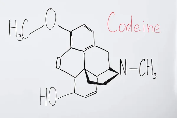 Top view of white board with chemical formula and lettering codeine — Stock Photo