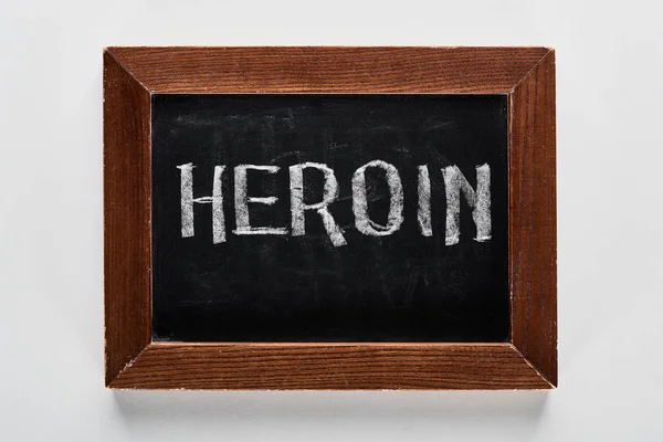 Vista superior da placa de giz preto com heroína lettering — Fotografia de Stock