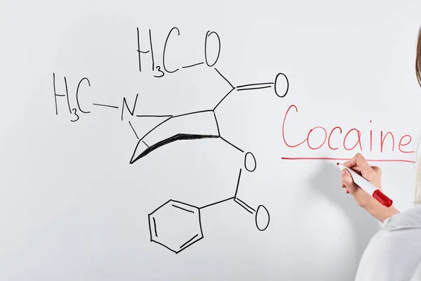 Cropped view of woman writing cocaine on white board — Stock Photo