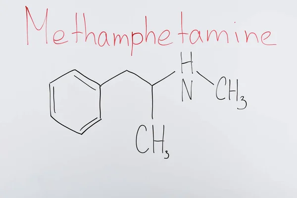 Top view of white board with chemical formula and lettering methamphetamine — Stock Photo