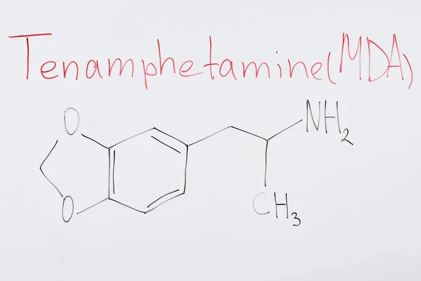 Top view of white board with chemical formula and lettering tenamphetamine (mda) — Stock Photo