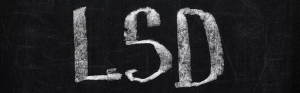 Panoramic shot of black chalk board with lettering lsd — Stock Photo