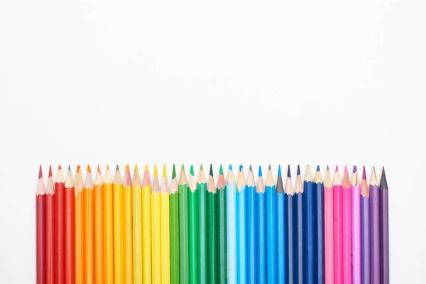 Spectre arc-en-ciel composé d'une rangée droite de crayons de couleur isolés sur du blanc — Photo de stock