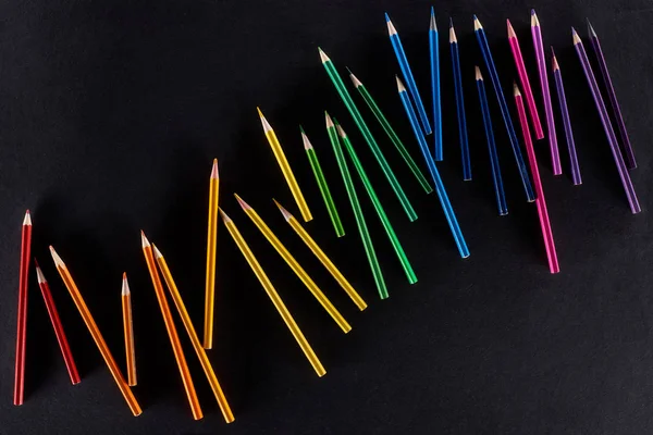 Gradiente arcobaleno realizzato con matite colorate affilate isolate su nero — Foto stock