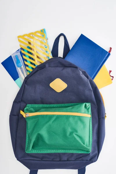 Borsa da scuola blu con tasca verde con taccuini e astuccio isolato su bianco — Foto stock