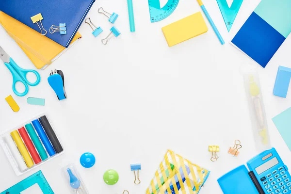 Top view of blue and yellow scattered school supplies isolated on white — Stock Photo