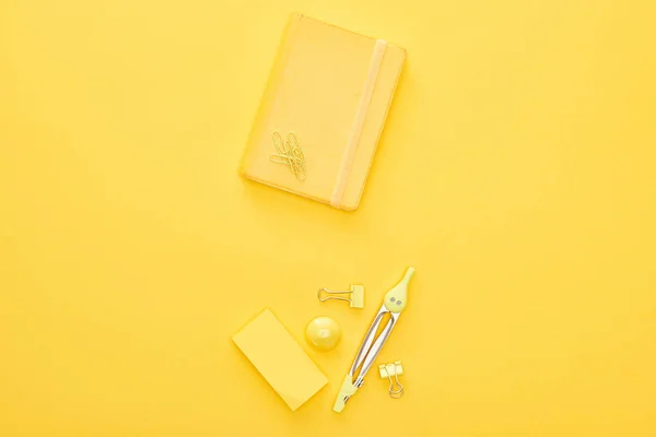 Top view of yellow notepad and stationery on same background — Stock Photo