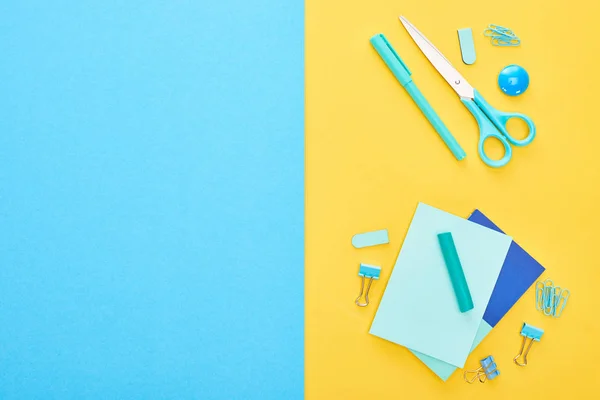 Vista superior de diferentes papelería azul con hojas de papel sobre fondo bicolor - foto de stock