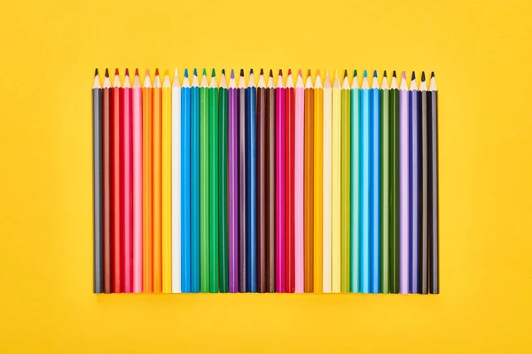 Panoramic shot of sharpened color pencils isolated on yellow — Stock Photo