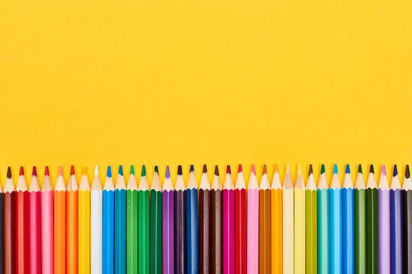 Crayons aiguisés de couleur vive isolés sur du jaune — Photo de stock