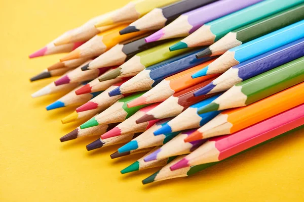 Набор заточенных цветных карандашей на желтом фоне — стоковое фото