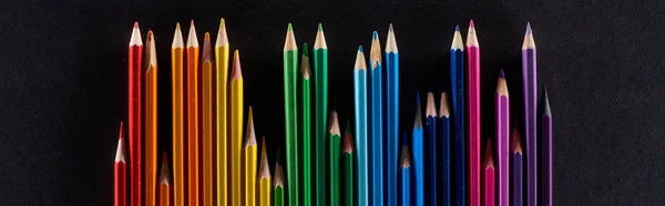 Панорамний знімок веселкового спектру, зроблений з прямого ряду кольорових олівців, ізольованих на чорному — стокове фото