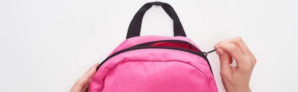 Tiro panorâmico de estudante zipando saco escolar rosa isolado no branco — Fotografia de Stock