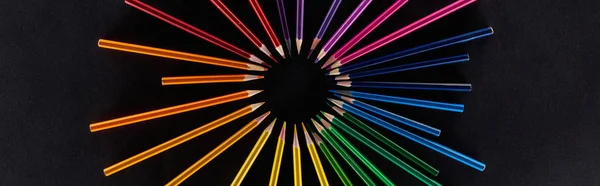 Panoramic shot of circular rainbow spectrum made with color pencils isolated on black — Stock Photo