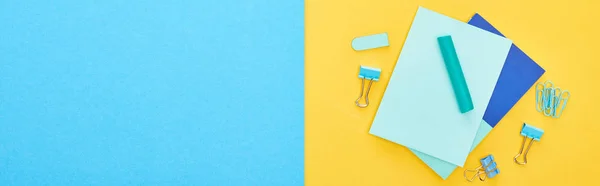 Fotografia panorâmica de diferentes artigos de papelaria azul com folhas de papel sobre fundo bicolor — Fotografia de Stock