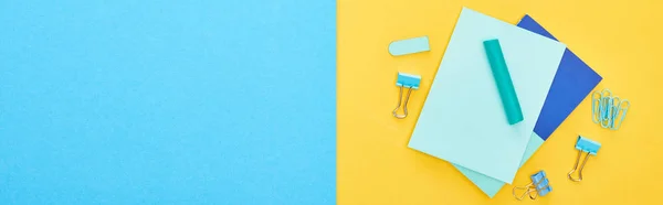 Foto panorámica de diferentes papelería azul con hojas de papel sobre fondo bicolor - foto de stock