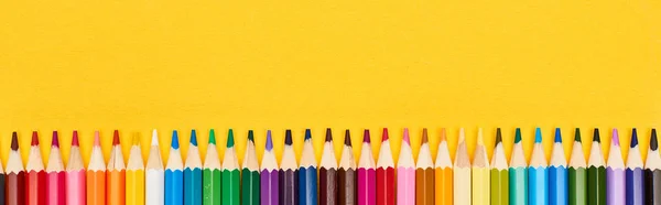 Foto panorámica de línea recta de lápices de color aislados en amarillo - foto de stock