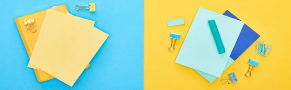 Top view of yellow and blue notepads near paperclips on bicolor background — Stock Photo