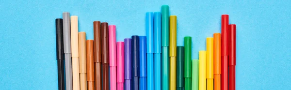 Tiro panorâmico do grupo de canetas de hidrográfica a cores brilhantes isoladas em azul — Fotografia de Stock