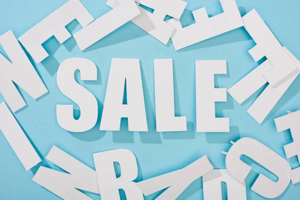 Draufsicht auf weißen Verkauf Schriftzug zwischen Buchstaben auf blauem Hintergrund — Stockfoto