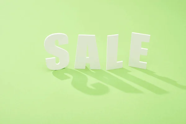 Scritta di vendita bianca con ombra su sfondo verde — Foto stock