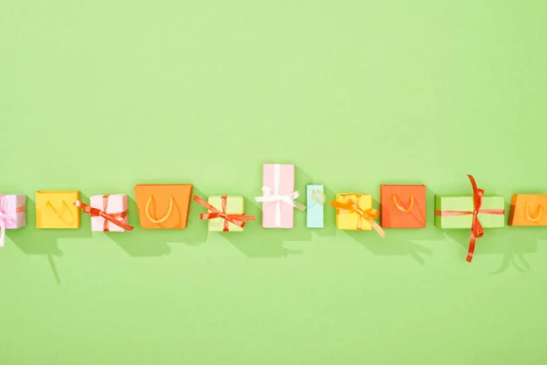 Вид на декоративные подарочные коробки и сумки на зеленом фоне с копировальным пространством — стоковое фото