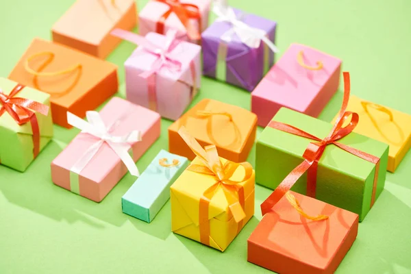 Selective focus of decorative colorful gift boxes on green background — Stock Photo
