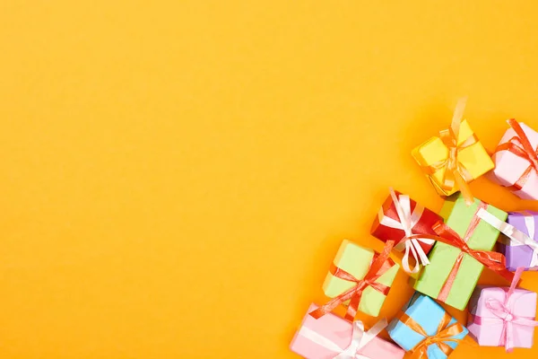Vista superior de las cajas de regalo envueltas festivas sobre fondo naranja brillante - foto de stock