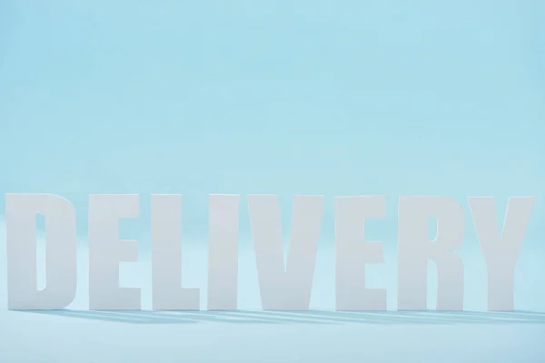 White delivery text with shadows on blue background — Stock Photo