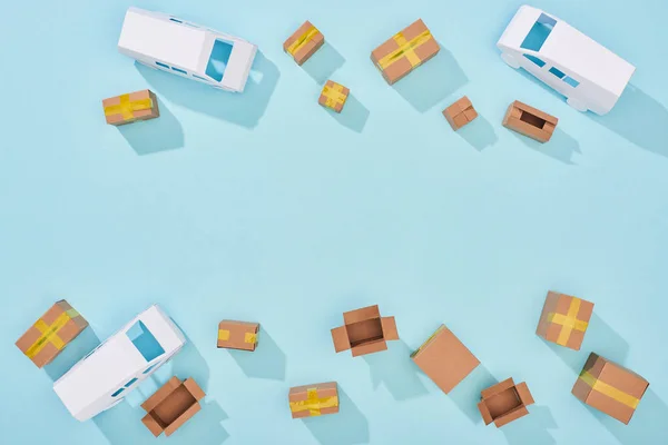 Top view of delivery vans models and carton boxes on blue background — Stock Photo