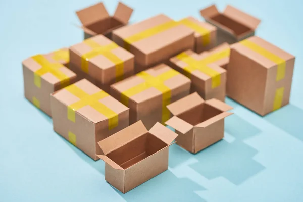 Miniature cardboard postal boxes on blue background — Stock Photo