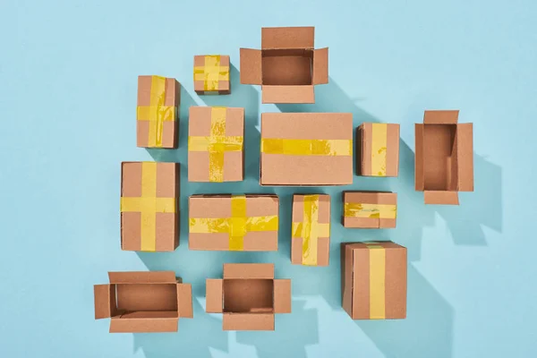 Top view of closed and open cardboard boxes on blue background — Stock Photo
