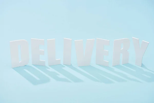 Delivery lettering with shadow on blue background with copy space — Stock Photo