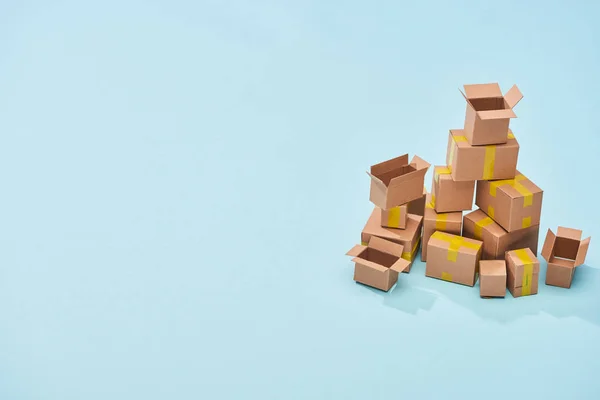 Pile of cardboard boxes on blue background with copy space — Stock Photo