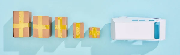 Panoramic shot of closed postal boxes near white mini van on blue background with copy space — Stock Photo