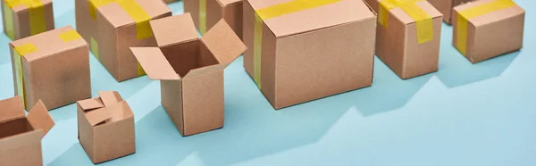 Plano panorámico de cajas postales de cartón sobre fondo azul - foto de stock