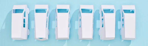 Panoramic shot of white miniature autos on blue background — Stock Photo